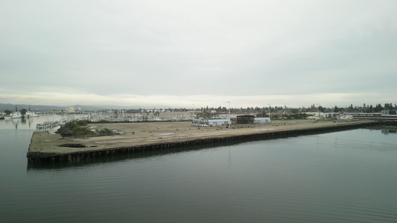 Encinal Basin drone view reveals the large pier with boats and yachts resting against the picturesque backdrop of Alameda's waterfront.
