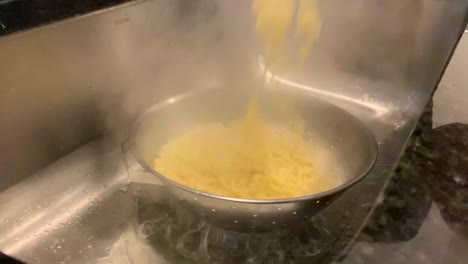 pouring boiled pasta water over sink slow motion