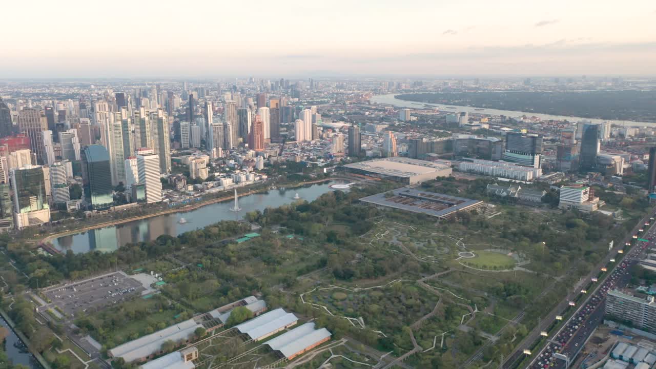 drone aéreo sobre el horizonte y los rascacielos del distrito de sukhumvit, pathum wan y lumphini park durante la puesta de sol en bangkok, tailandia