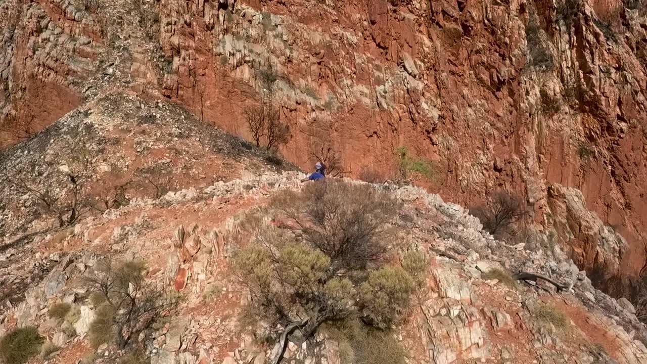 Kings Canyon Australia, Orbit shot of couple standing arms outstretched on mountain top
