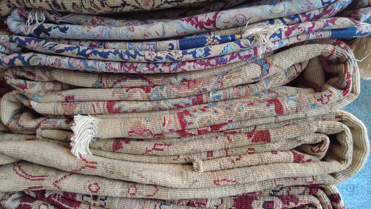 Stacked rolled rugs with intricate patterns