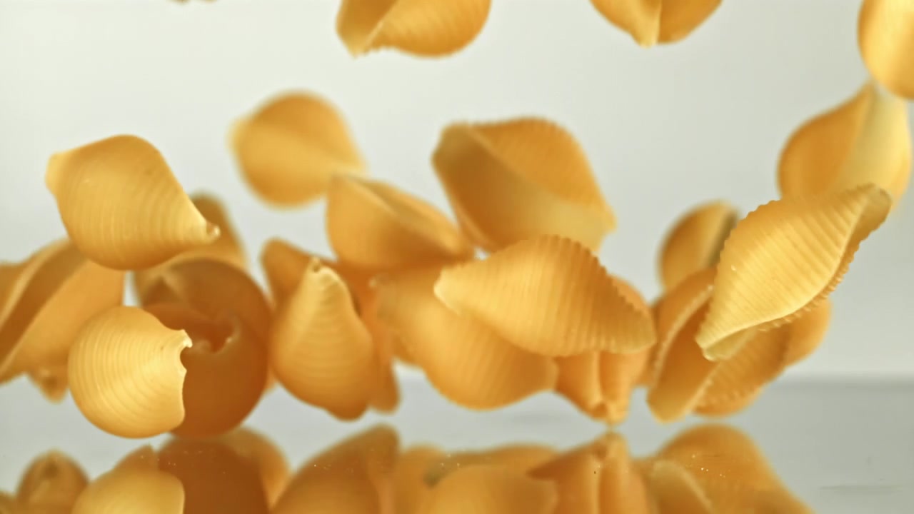 Conchiglie secche che cadono su una superficie riflettente
