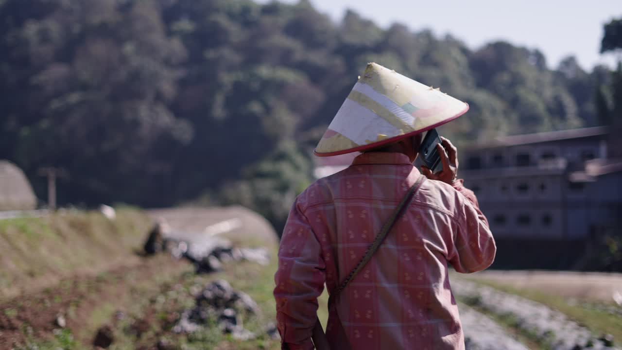 Person in Conical Hat Working in a Rural Farm Field