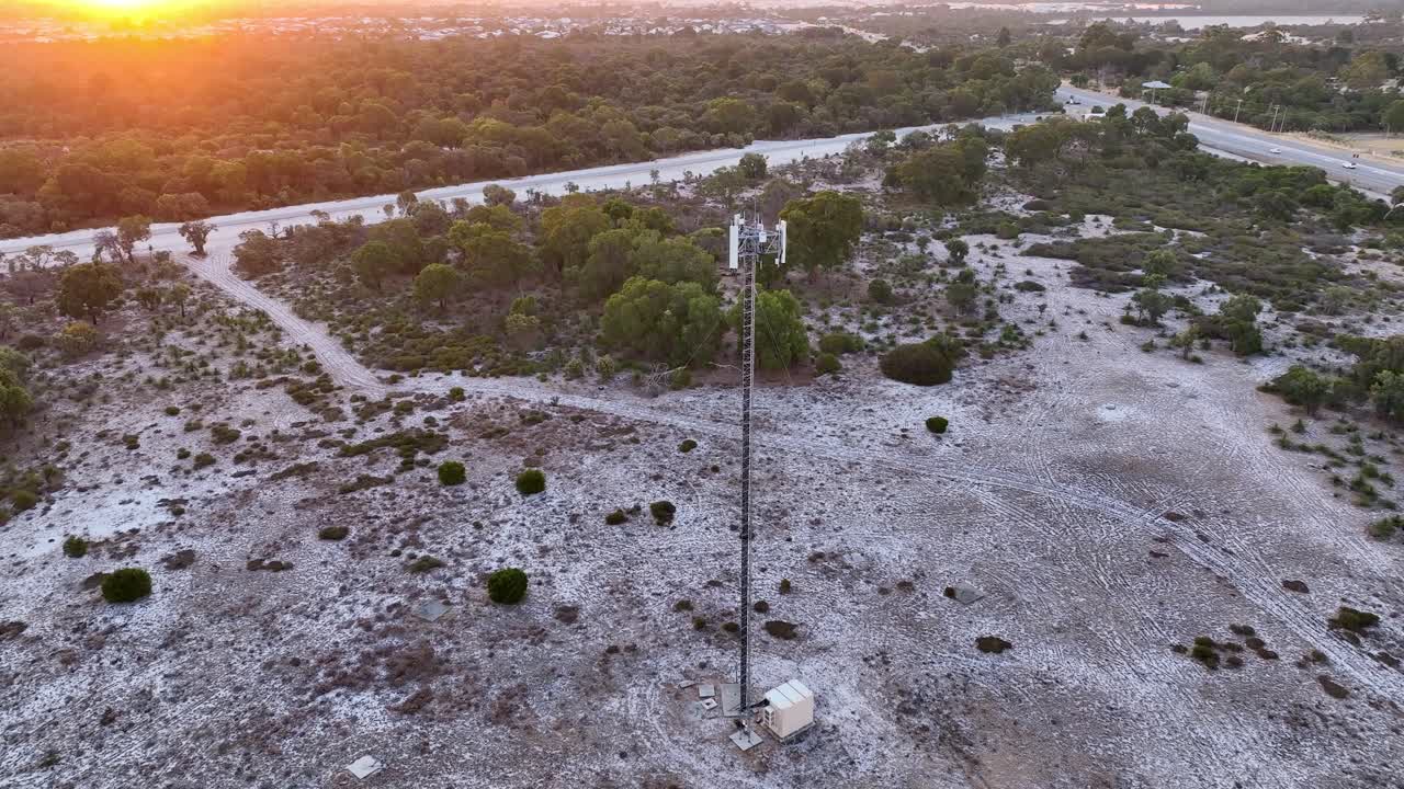 Pan view of telco tower installed at countryside land during sunset. Drone shot.