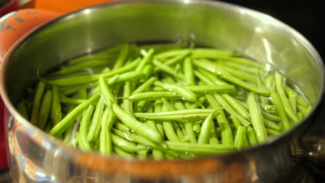 fresh green beans in water in a cooking pot