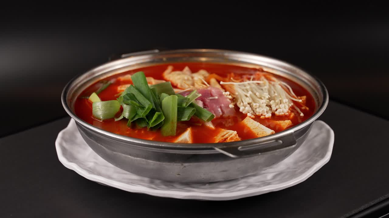 A hearty, spicy stew with aged kimchi, tender meat, and fresh vegetables in a rich broth. 숙성 김치와 부드러운 고기가 어우러진 얼큰한 국물 요리.