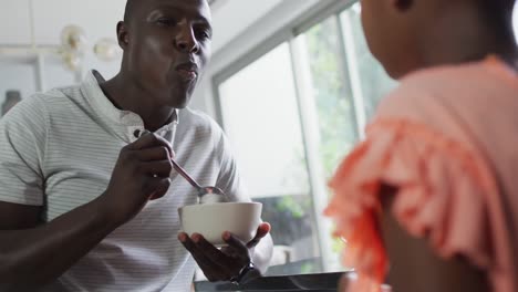 video de un padre y una hija afroamericanos preparando el desayuno