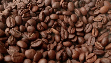 close up of seeds of coffee. fragrant coffee beans are roasted smoke comes from coffee beans.