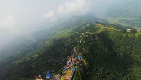 village nestled embrace of mountains, hills kissed by morning fog, as seen from an fpv drone