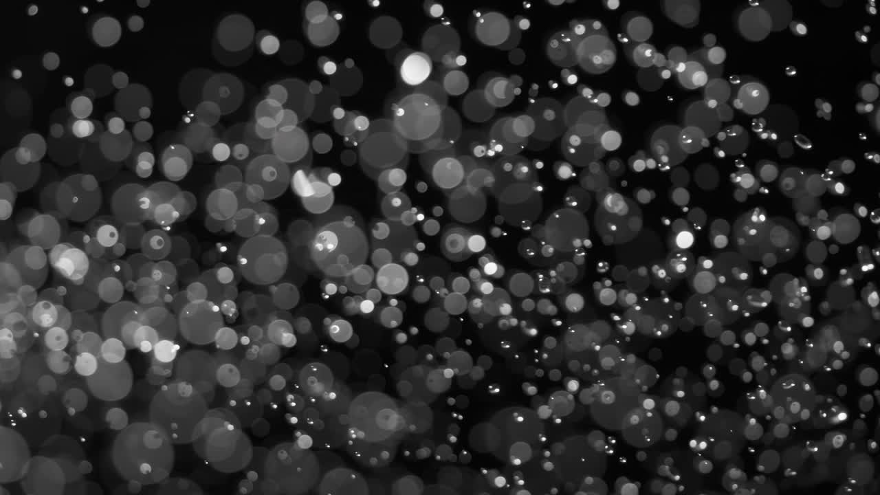 Floating abstract particle bokeh on dark background. Shot on super slow motion camera 1000 fps