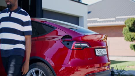 hombre cargando coche eléctrico en casa