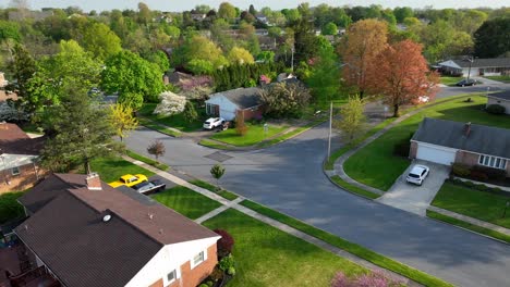 Aerial-view-of-idyllic-neighborhood-with-large-single-family-houses-in-green-suburb-at-sunset-time