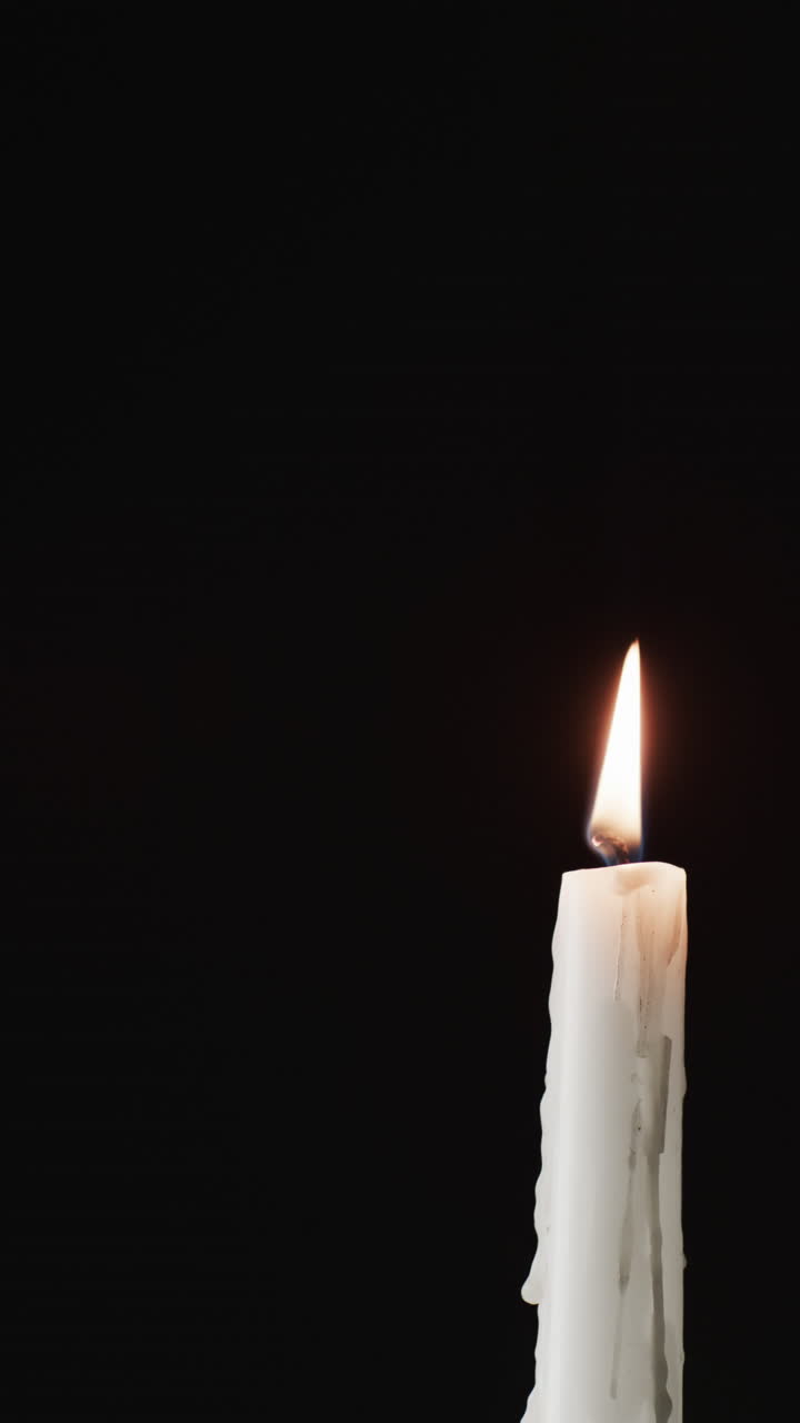 Vertikální video zapálené svíčky a prostoru pro text na černém pozadí