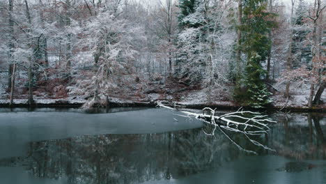 Drone-pushes-over-an-icy-river-towards-a-road-in-the-woods