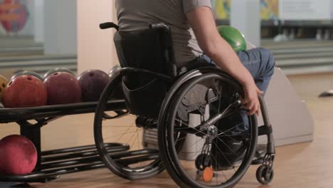 two young disabled men in wheelchairs playing bowling in the club