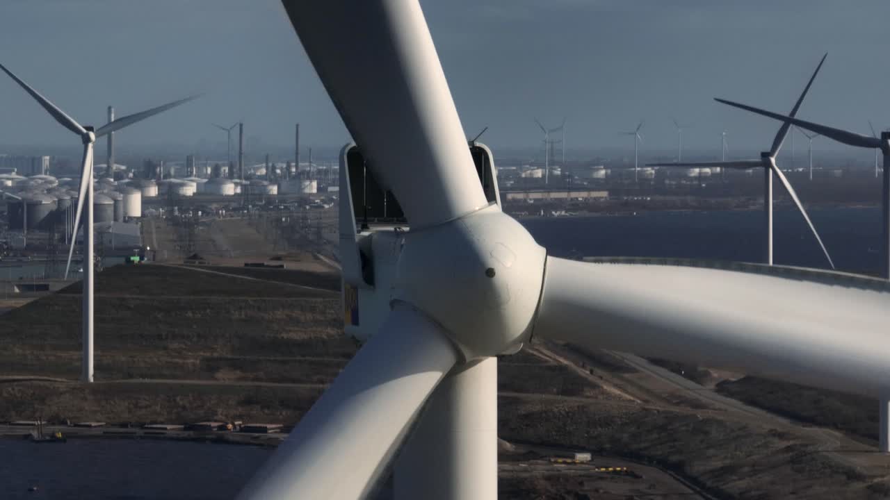 Wind Turbine Farm with Oil Refinery Background