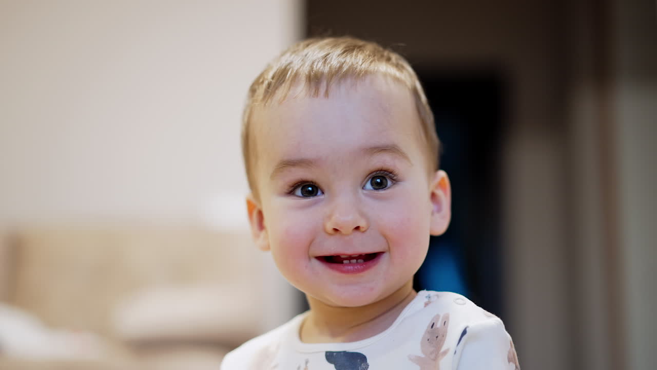 Happy healthy Caucasian toddler smiling adorably to the camera. Kid is joyful for getting a toy. Close up portrait.