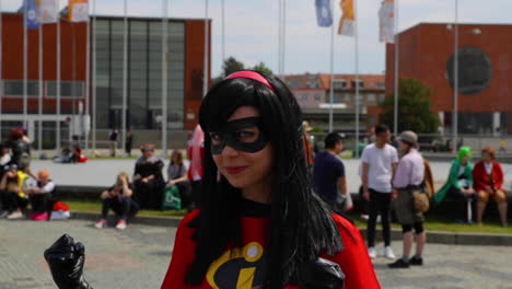 women in black mask and her hand flex to camera in homemade comics costume in public event during a meeting of anime comics and manga lovers animefest brno expo camera in 120fps.