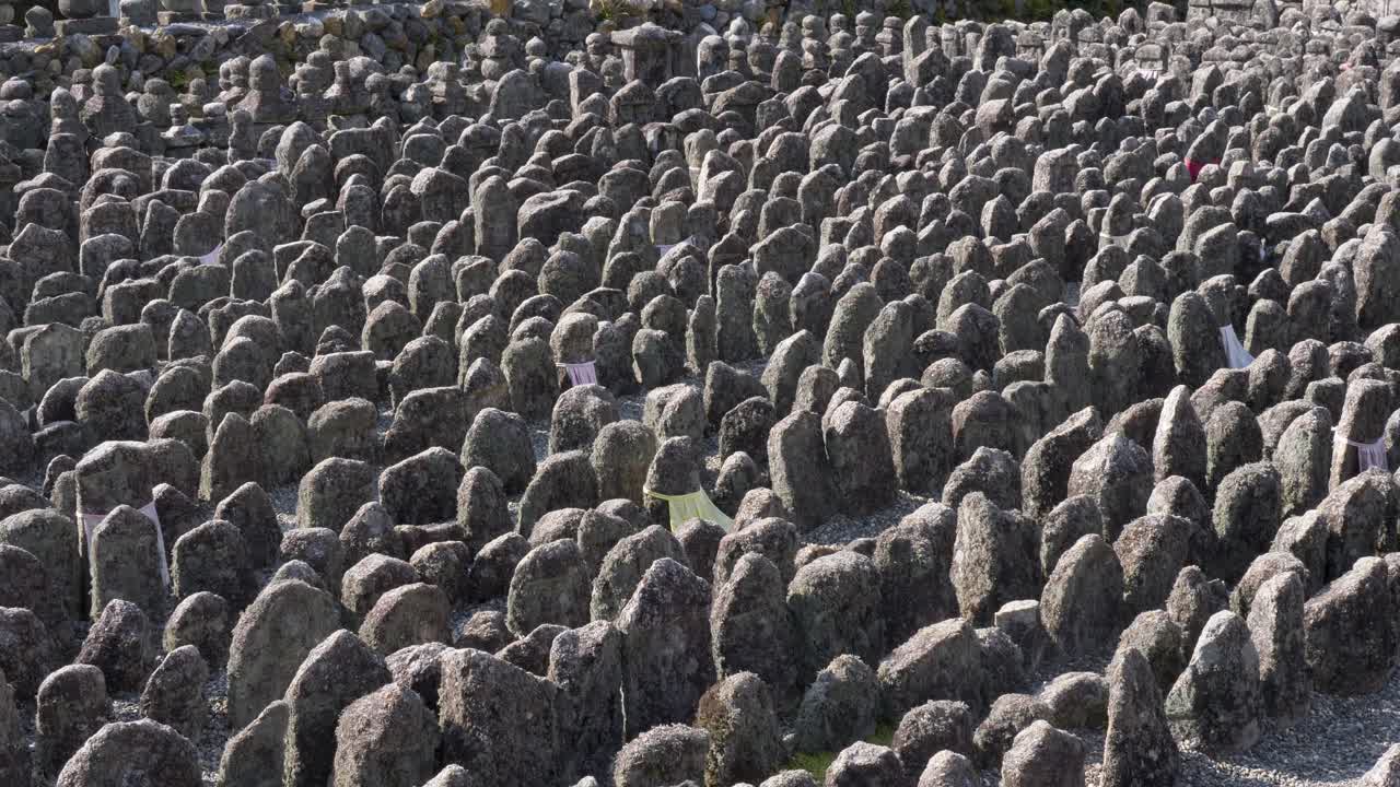 Slowmotion-landskab med hundredvis af hellige stenstatuer og klippemonumenter opstillet på det buddhistiske tempelområde Adashino Nenbutsuji i Kyoto Ukyo Ward, Japan – Asien turisme og kultur