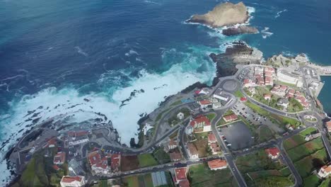 porto moniz with natural pool and crashing waves against coastline during sunny day