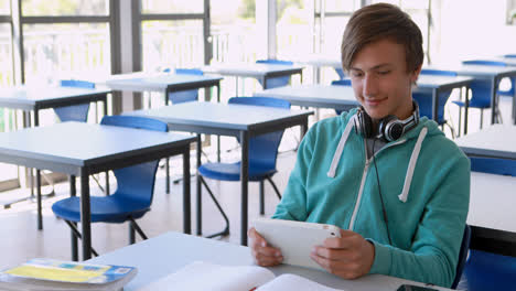 schoolboy using digital tablet in classroom