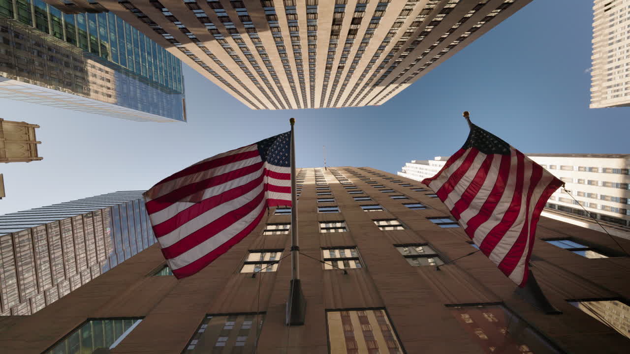 Inquadratura dal basso di grattacieli con bandiere americane a Manhattan, New York City, prospettiva dell'architettura urbana e del quartiere finanziario.