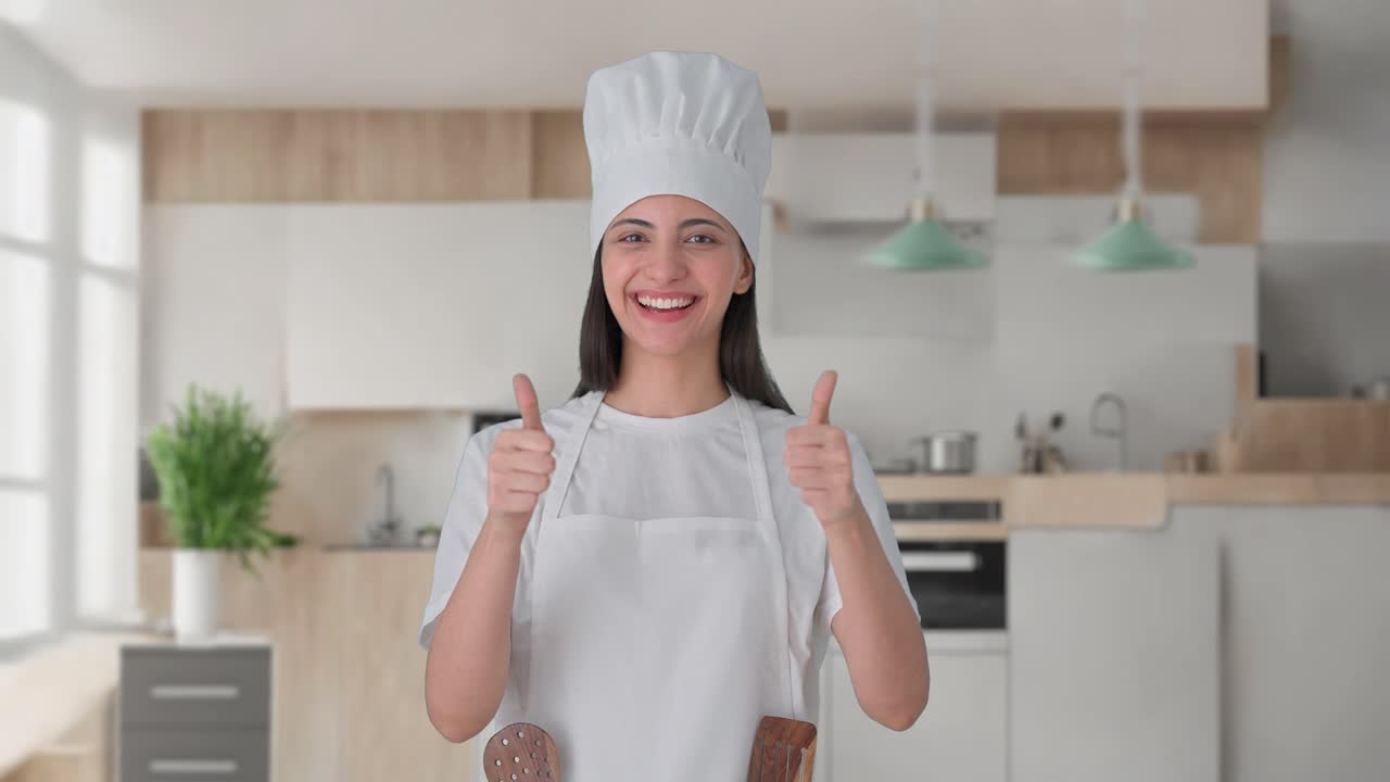 feliz india mujer chef profesional mostrando los pulgares hacia arriba