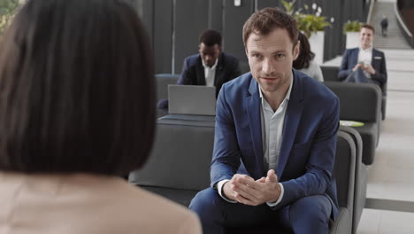 businessman talking to unrecognizable female coworker