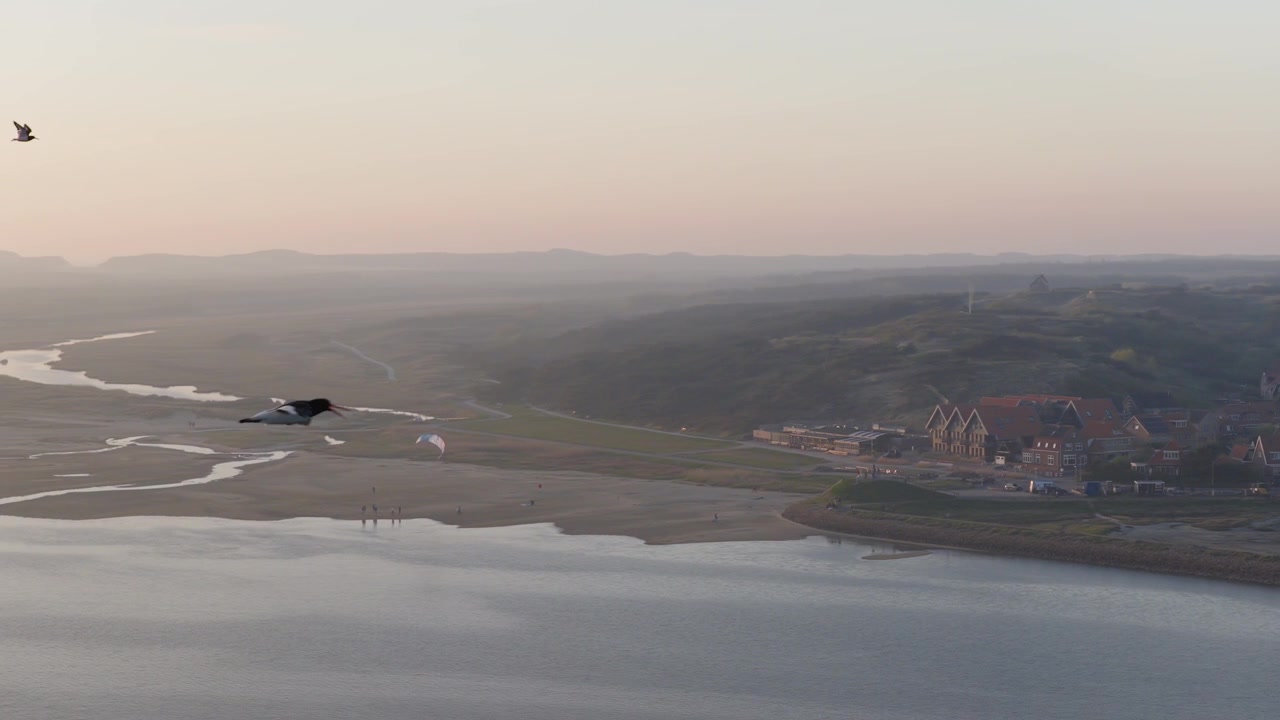 Vadehavet nära West-Terschelling, Terschelling, Friesland, Nederländerna, som visar en kitesurfare som förbereder utrustning, slingrande tidvattenkanaler, sandig strandlinje och Vadehavskusten, flygfoto