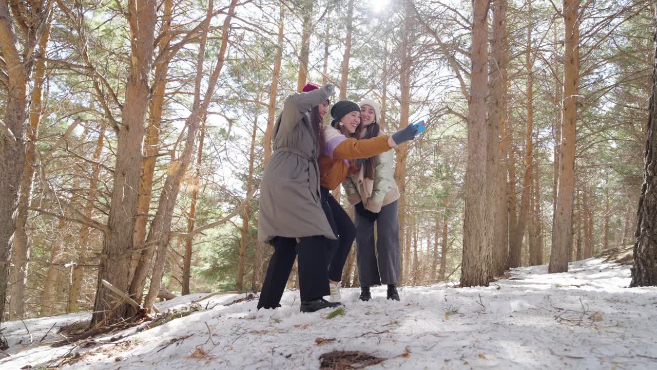 Friends taking a selfie in winter forest