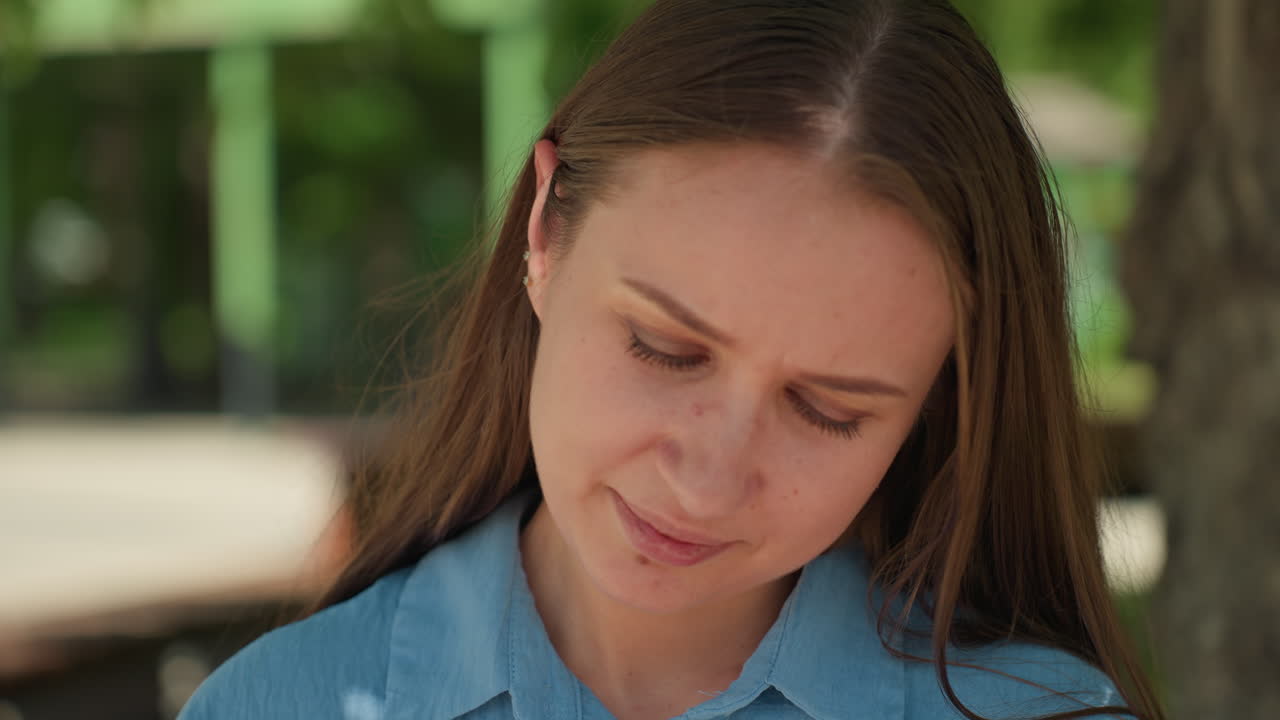 Profesora examinando el horario en el exterior, instructora estudiando el plan de estudios en el campus, educadora analizando cuidadosamente el programa sentada en un banco del parque en medio de un exuberante entorno del campus