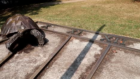 sundial of a bronze ground turtle sculpture marking the hours on the ground