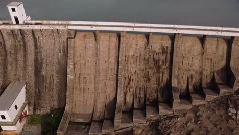 establish aerial of tratalias dam, tilt down and up reveals beautiful lake, day