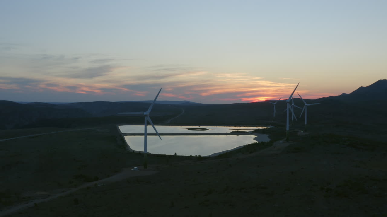 Wind Farm at Sunset Over a Mountain Lake