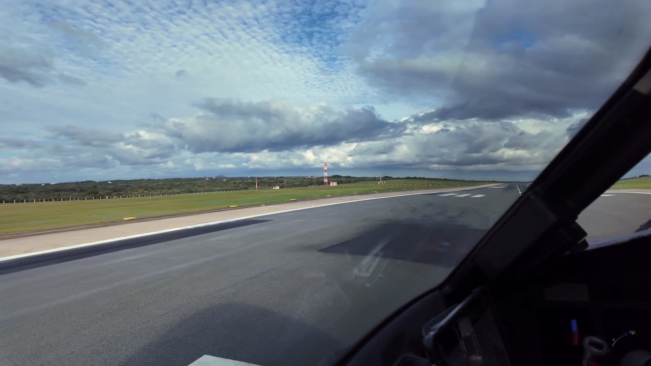 A pilot’s eye view recorded from inside a jet cockpit lining up for takeoff with stormy clouds over the runway