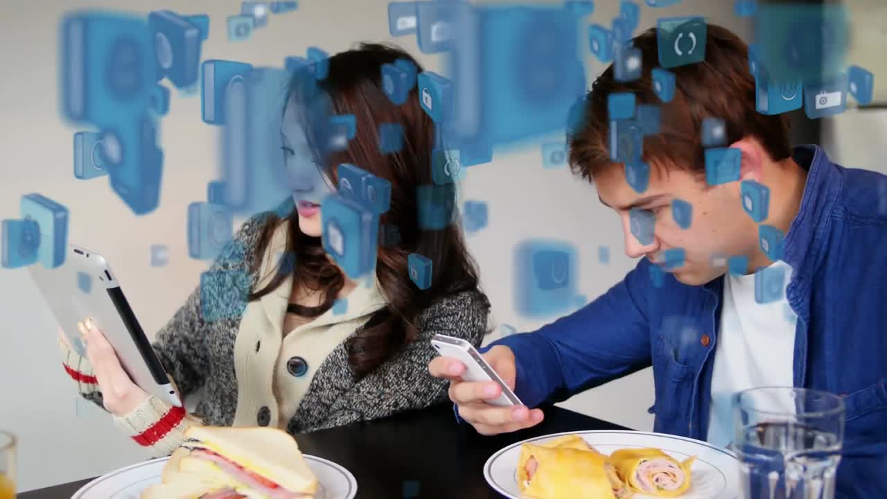 여러 개의 디지털 아이콘이 전자 장치를 사용하여 남성과 여성에 대해 떠다니고 있습니다.