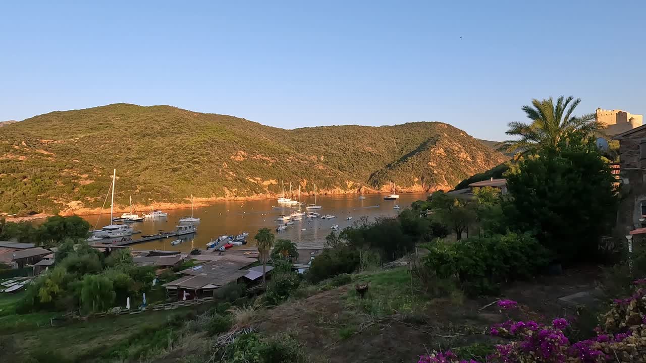Panoramic panning view of Girolata harbor with moored boats