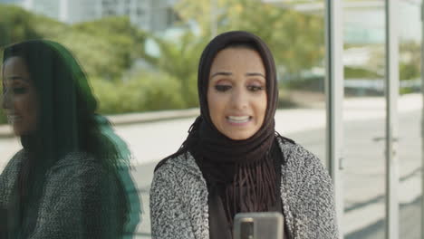 close-up of young muslim woman having video call outdoors.