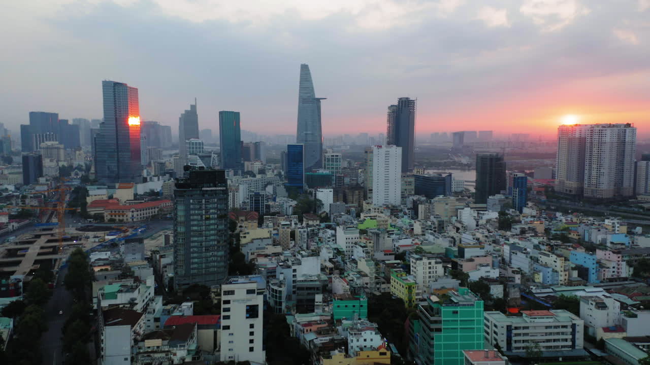 Aerial shot of Ho Chi Minh, high view to downtown and Saigon river at sunset