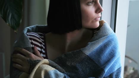mujer envuelta en una manta relajándose en casa 4k