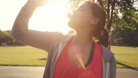 fitness woman drinking water outdoors in park