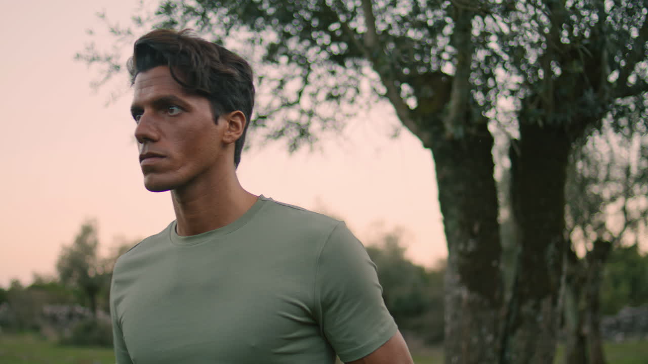 granjero serio caminando plantación de olivos primer plano. hombre cansado yendo después de la cosecha