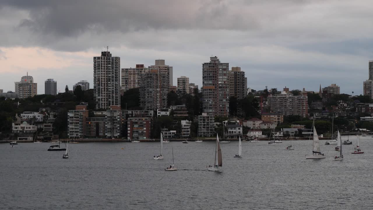 Small sailboats and yachts in Port Jackson, Sydney, Australia. Cloudy day.