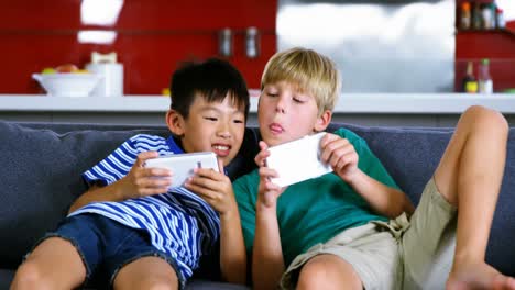 siblings using mobile phone in living room