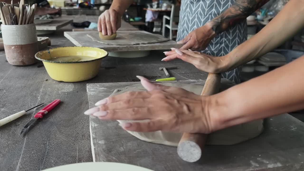 Mani di artigiani che lavorano l’argilla in uno studio di ceramica