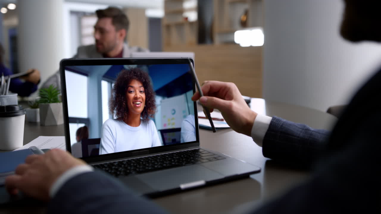 Woman talking virtual chat at laptop screen in company coworking office close up