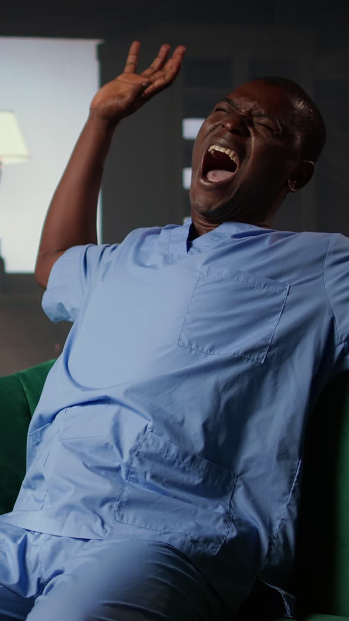 Tired African American Man in Scrubs Yawning