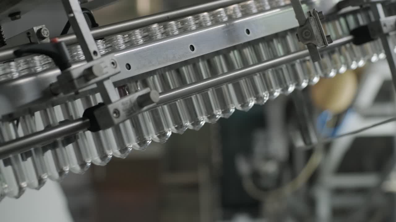 la máquina de llenado automático vierte agua en botellas de plástico para mascotas en una moderna planta de bebidas