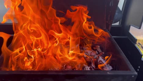 bright orange flames engulf a barbecue grill