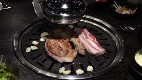 samgyeopsal - barbacoa coreana de vientre de cerdo asado a la parrilla con ajo en un restaurante